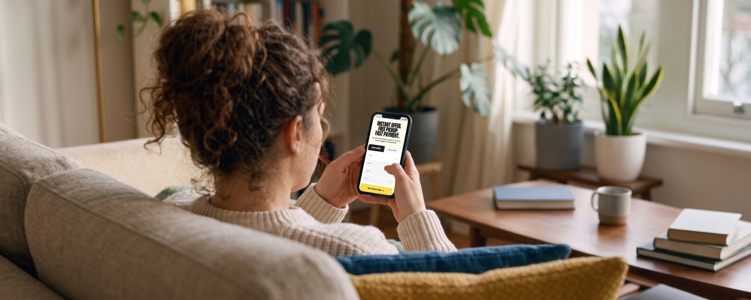Smiling woman relaxing on her couch and checking her car's value on her phone