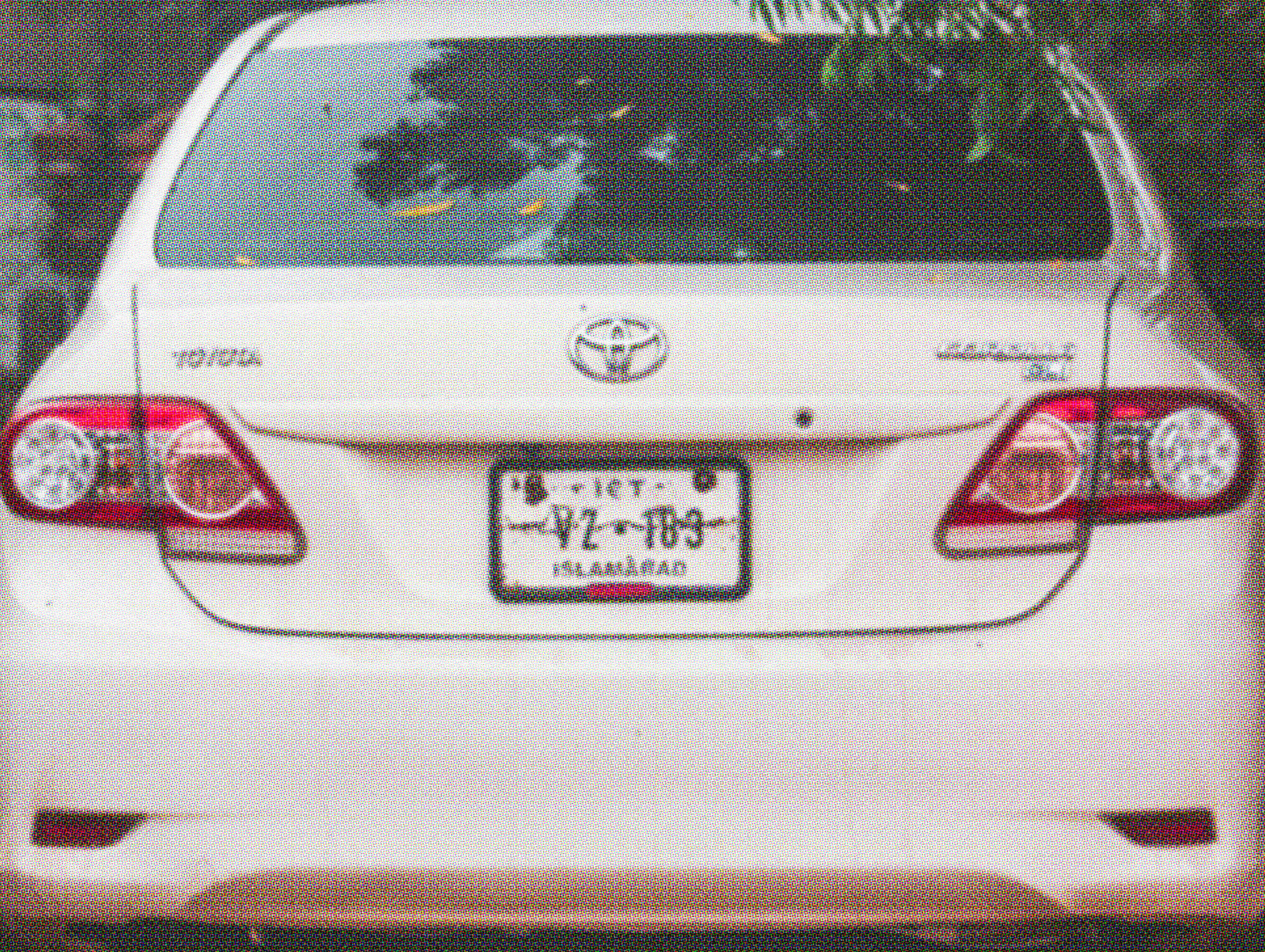 White Toyota Corolla sedan rear view parked outdoors