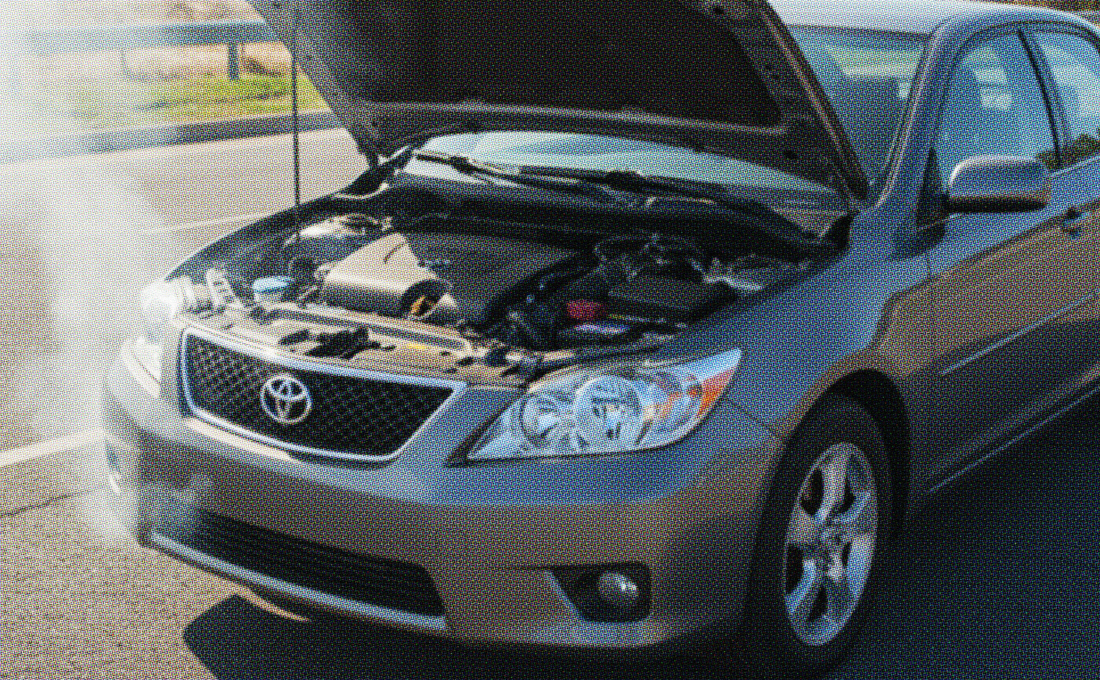 Toyota sedan with a blown engine, hood open, and smoke coming from the engine on the roadside.