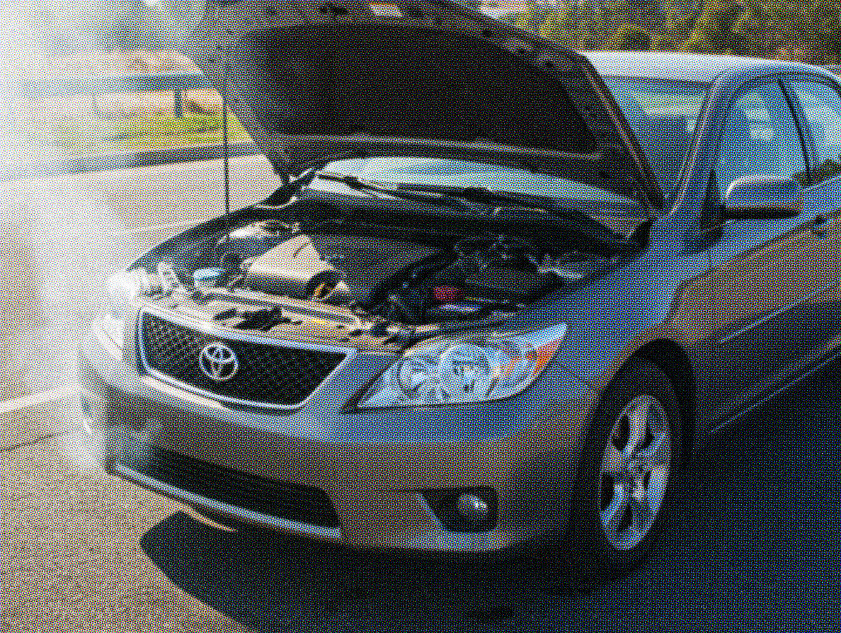 Sedan parked on the roadside with the hood open, showing signs of engine failure or a blown engine after breaking down.