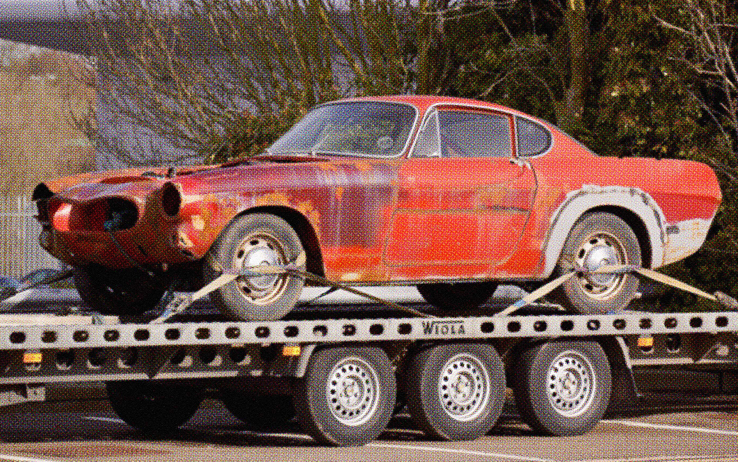 red junk car on tow truck