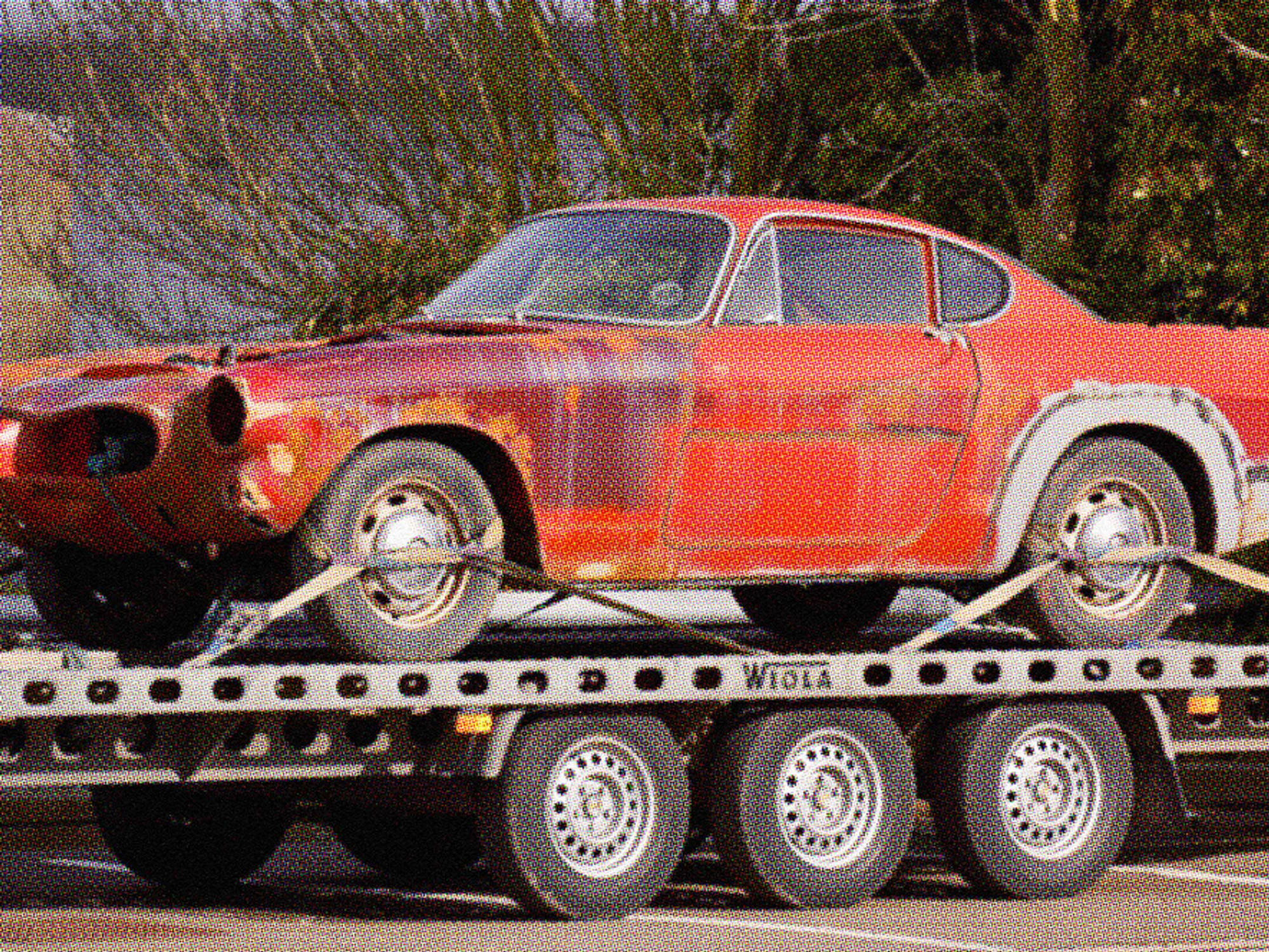 red junk car on tow truck