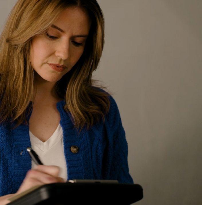 Woman filling out paperwork to complete the process of selling her car