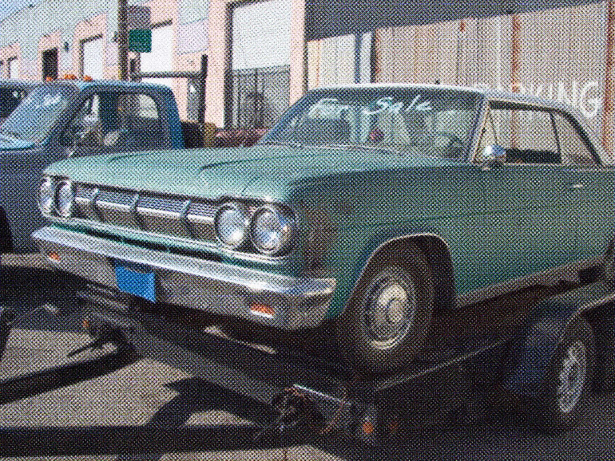 old turquoise car on trailer