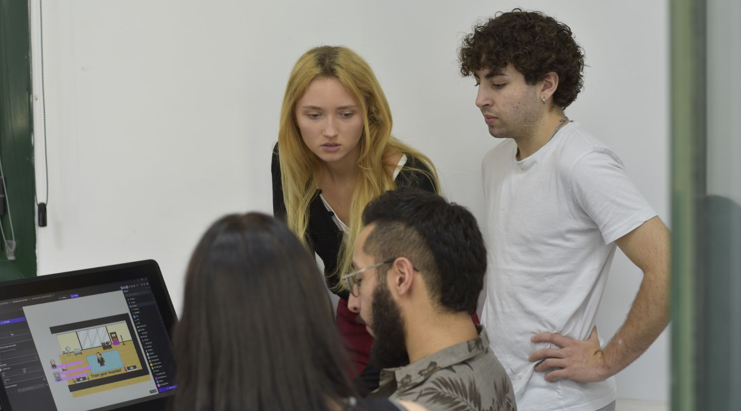 Adriana and Elio showing Kpop Trainee Simulator to their teacher Eduardo.