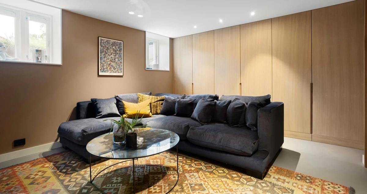Black sofa with pillows in the corner of a cozy living room, perfect for long-term TDY stays, aligning with the 2026 demand forecast for military furnished rentals