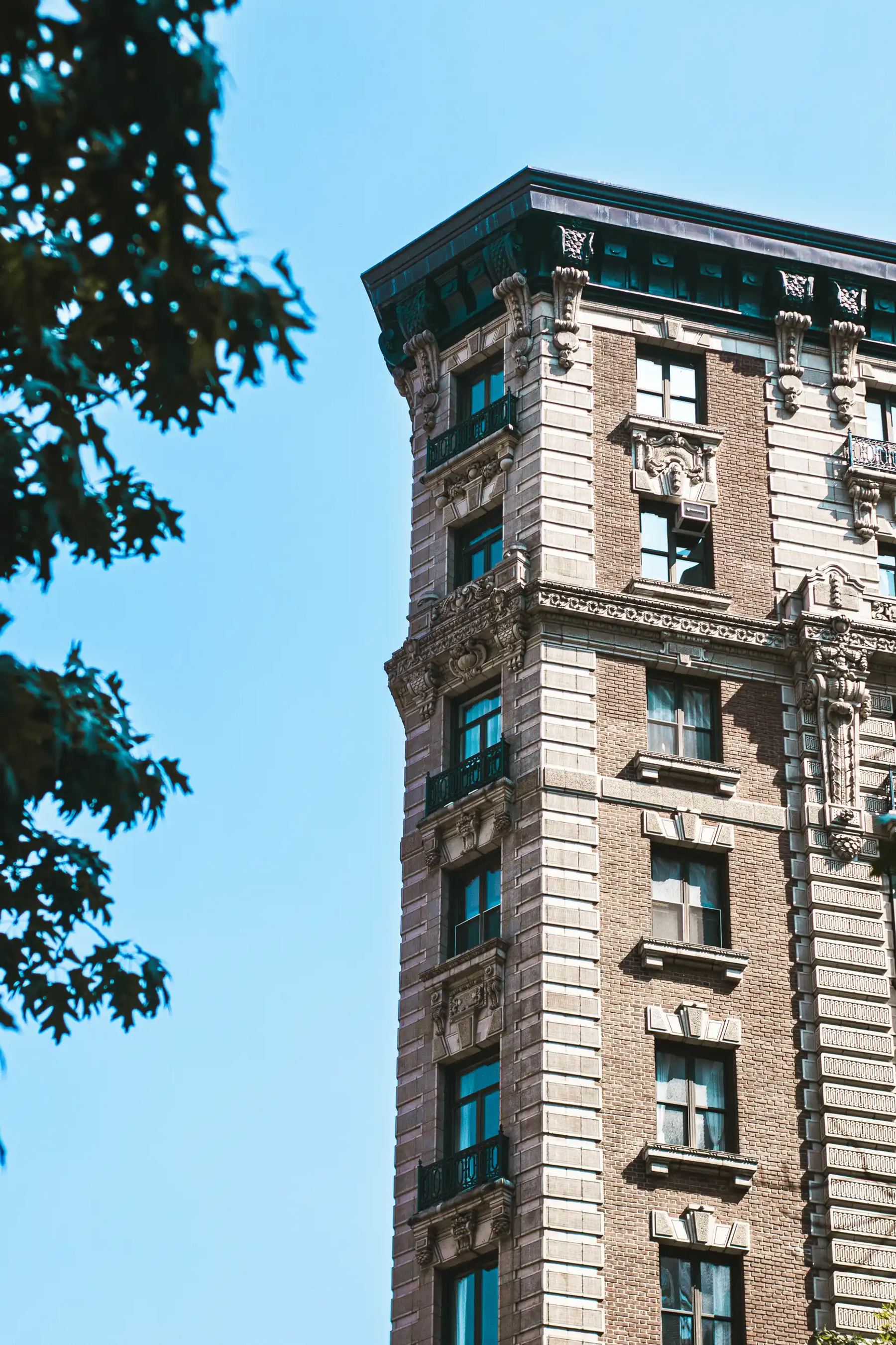 A low-angle shot of a grand, historic brick building against a clear blue sky.