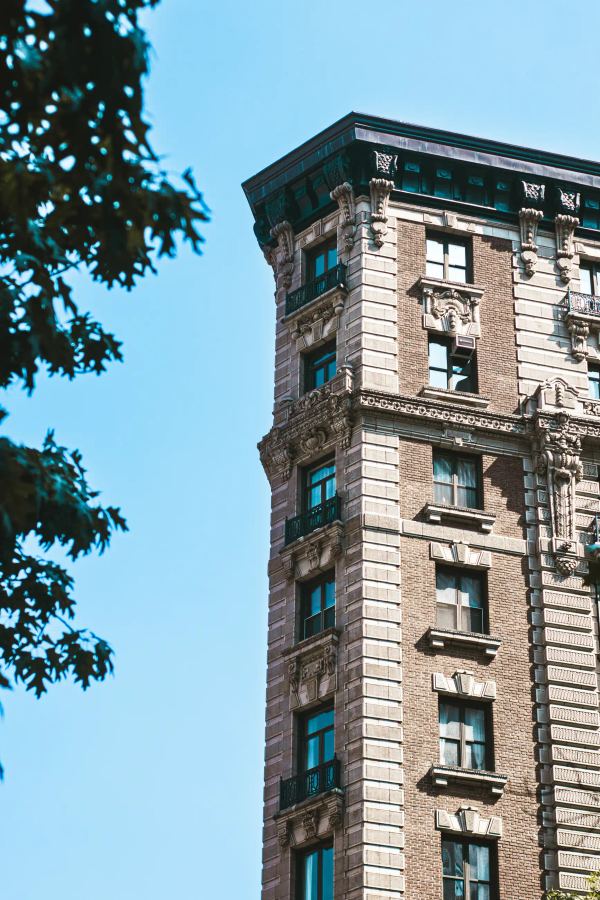 A low-angle shot of a grand, historic brick building against a clear blue sky.