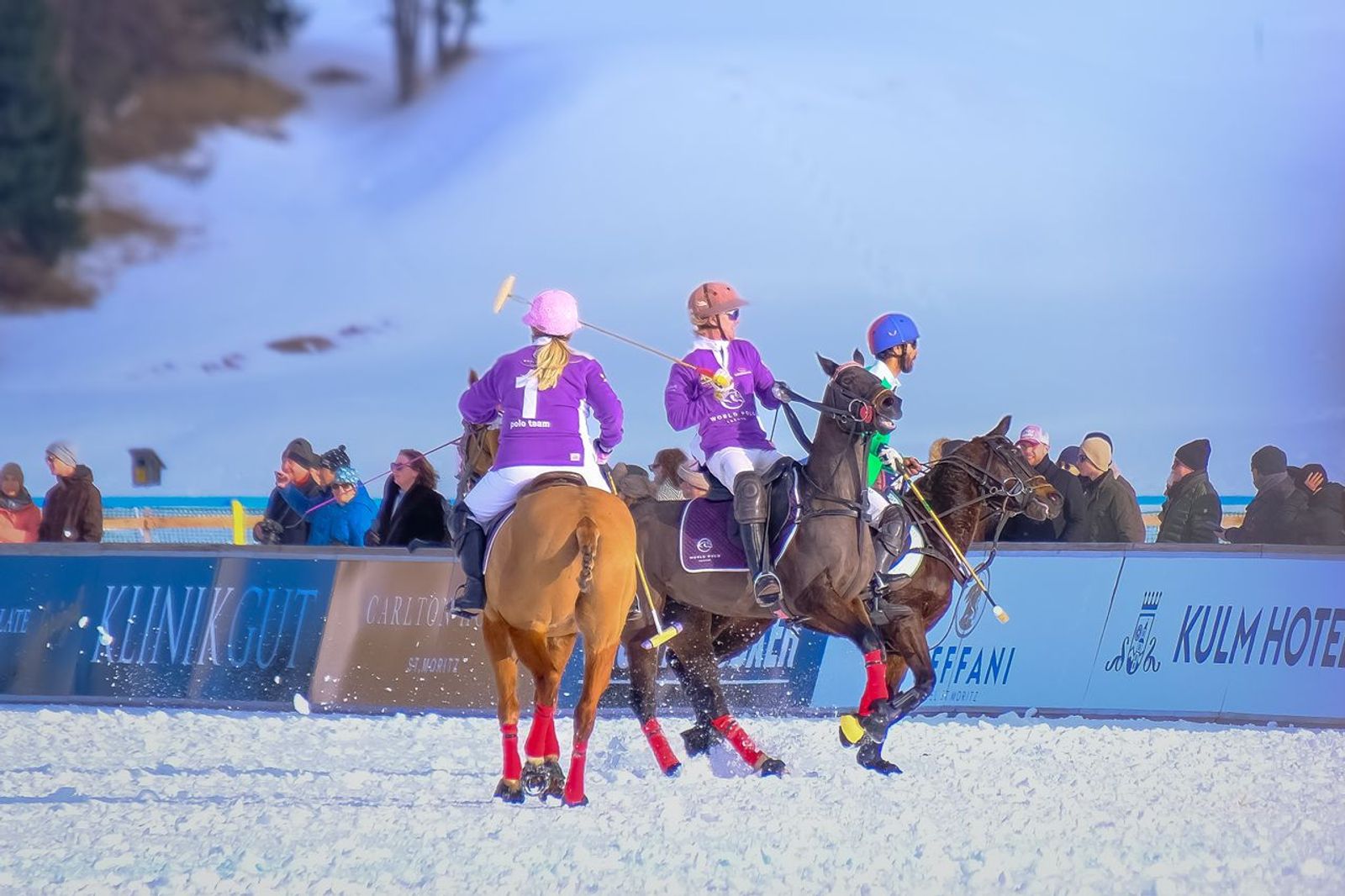 Polo players on horseback competing on a snow-covered field in St. Moritz.