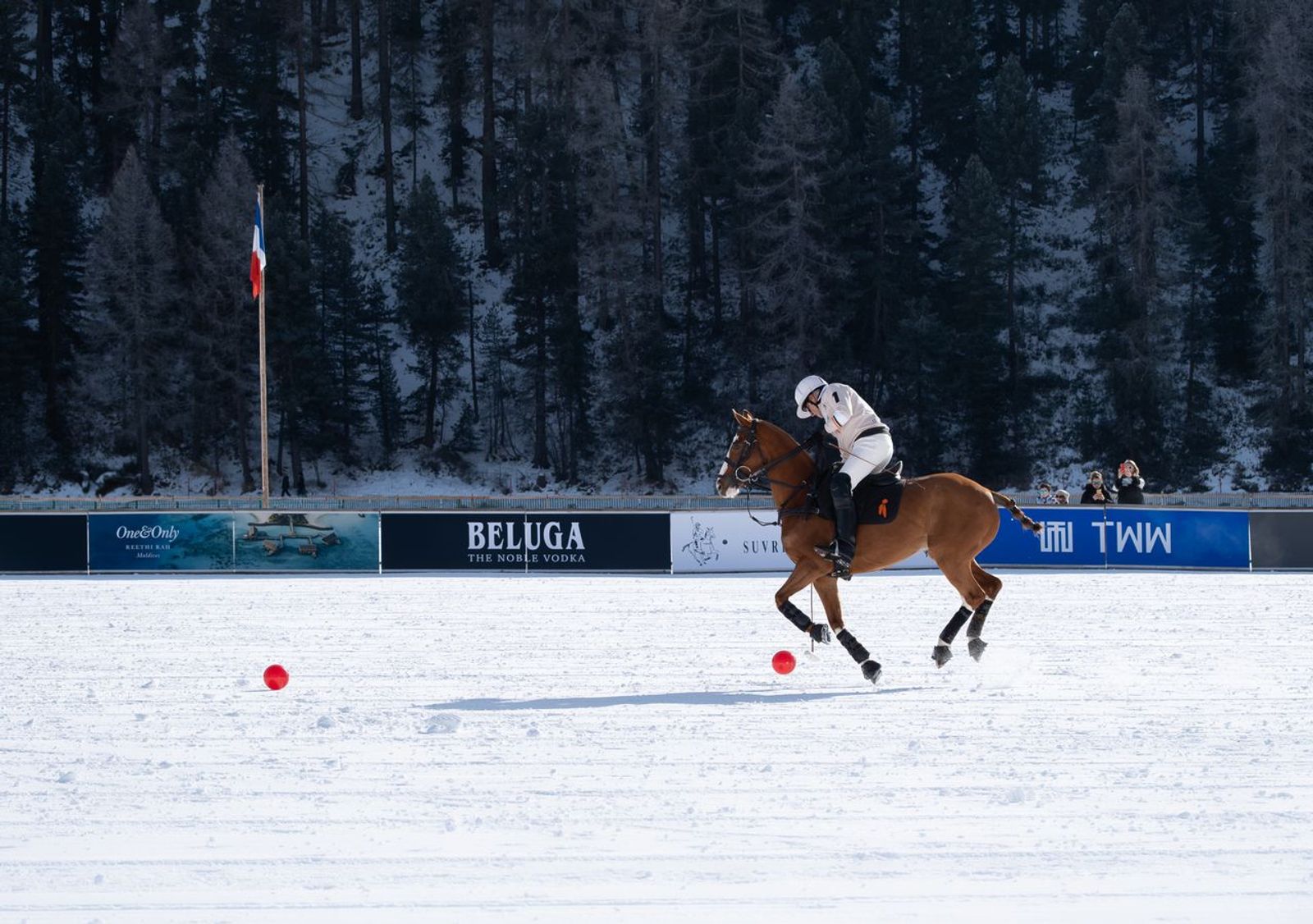 Polo player riding across the snow during a winter polo match