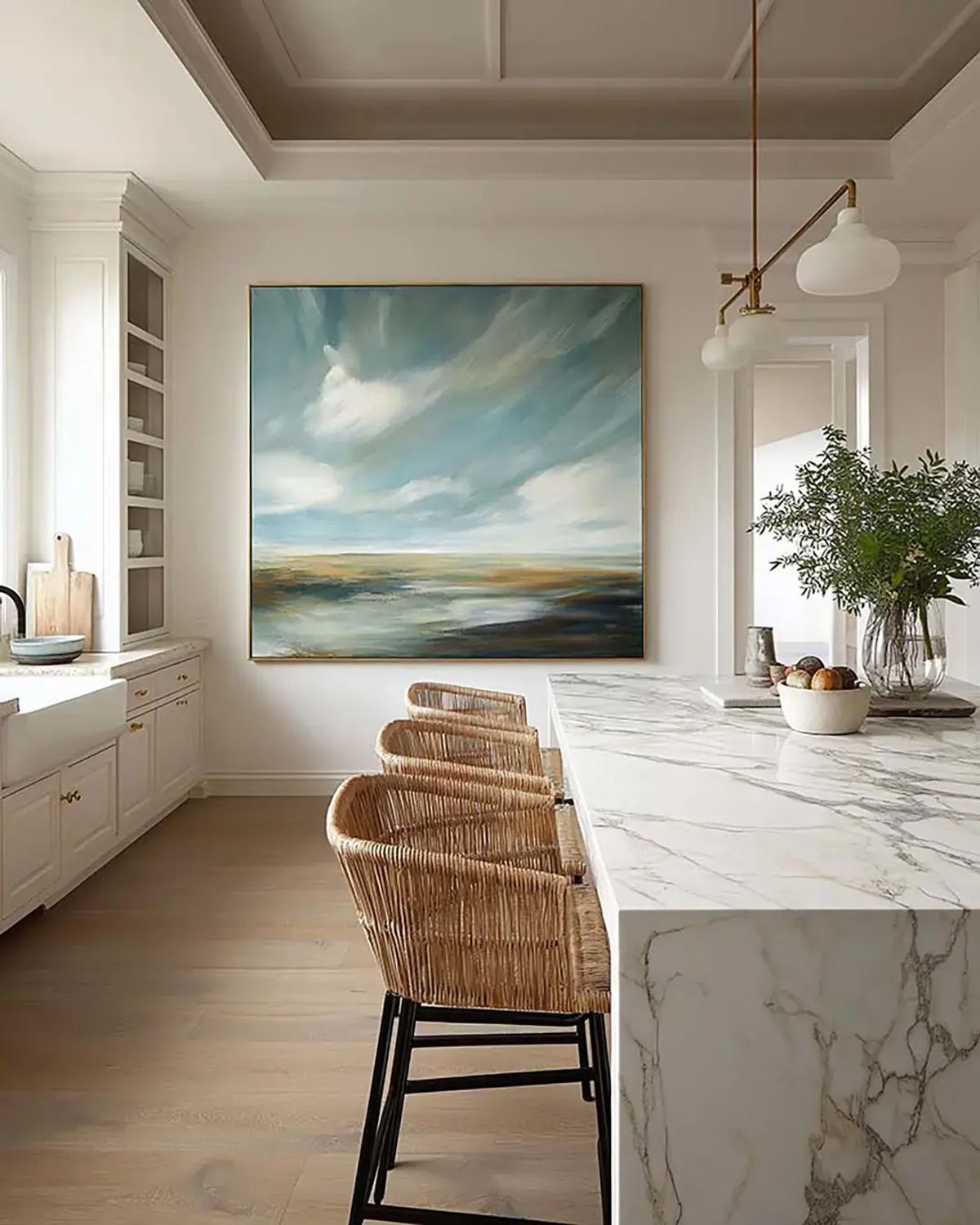 Large-scale landscape print above a marble island-archival substance for a considered kitchen.