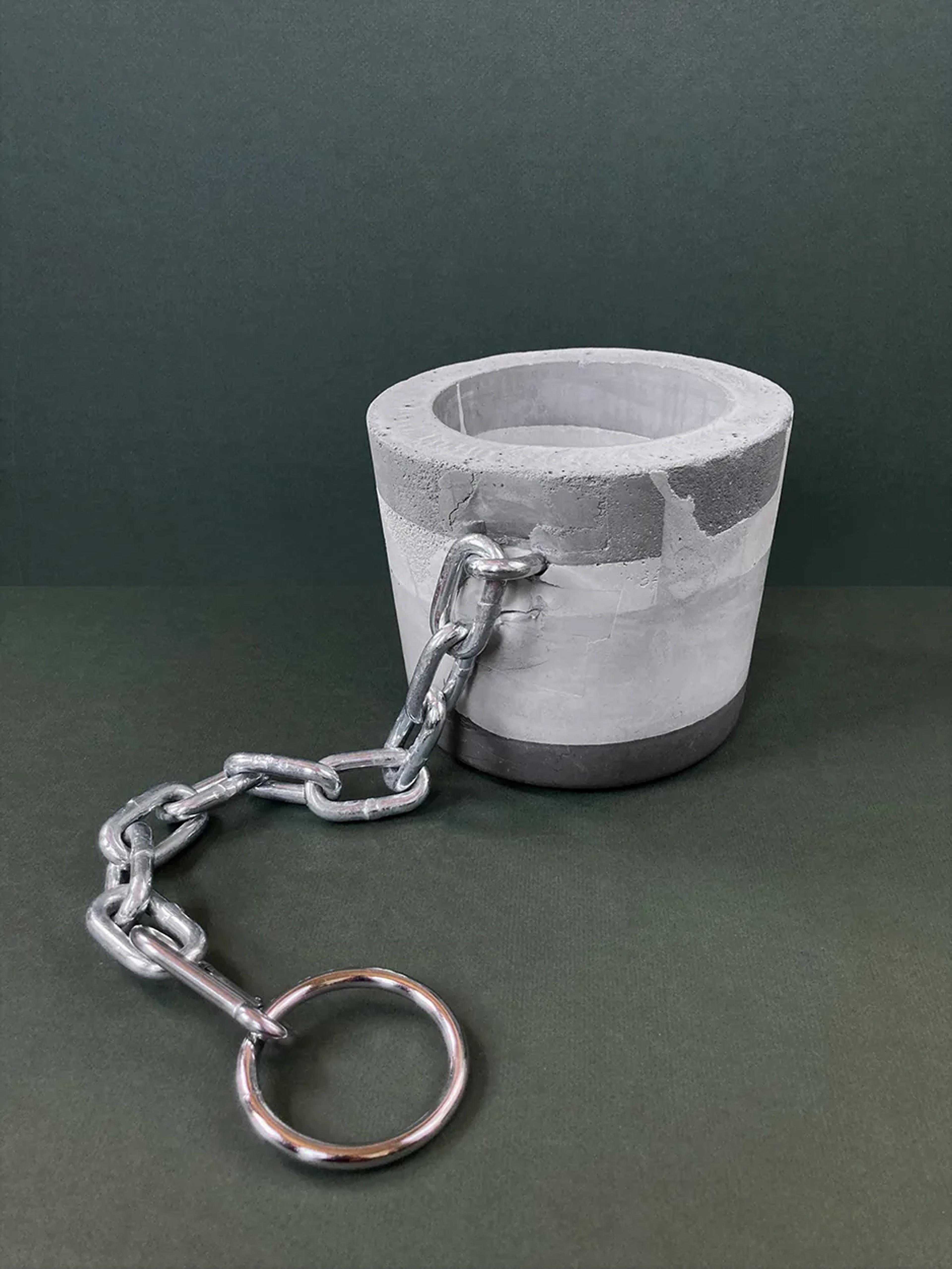 Anyone but You — a concrete planter with a chain and keyring, unplanted