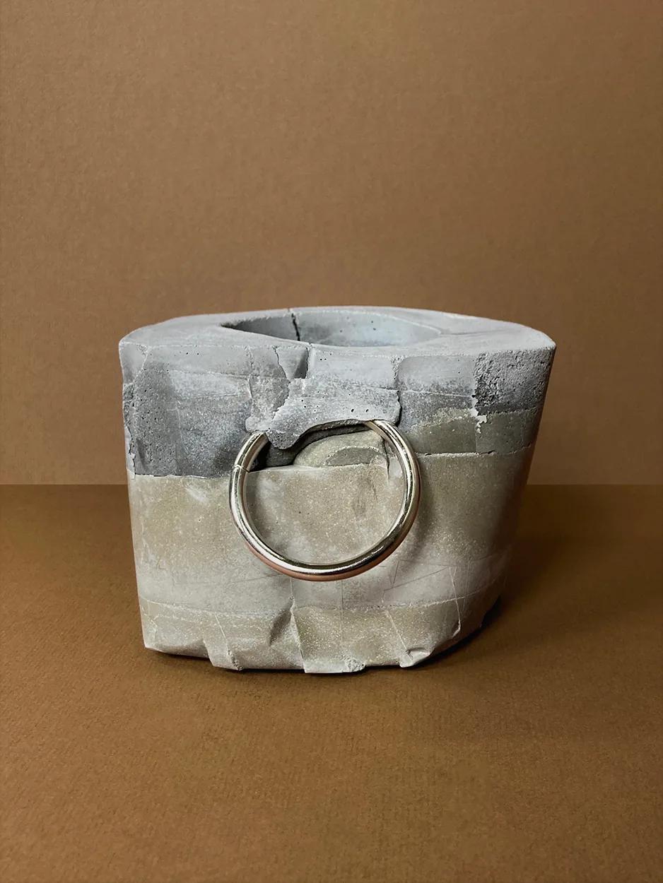 Kinky Planter #10 — a faceted concrete planter with a single ring, unplanted, view 1 of 3