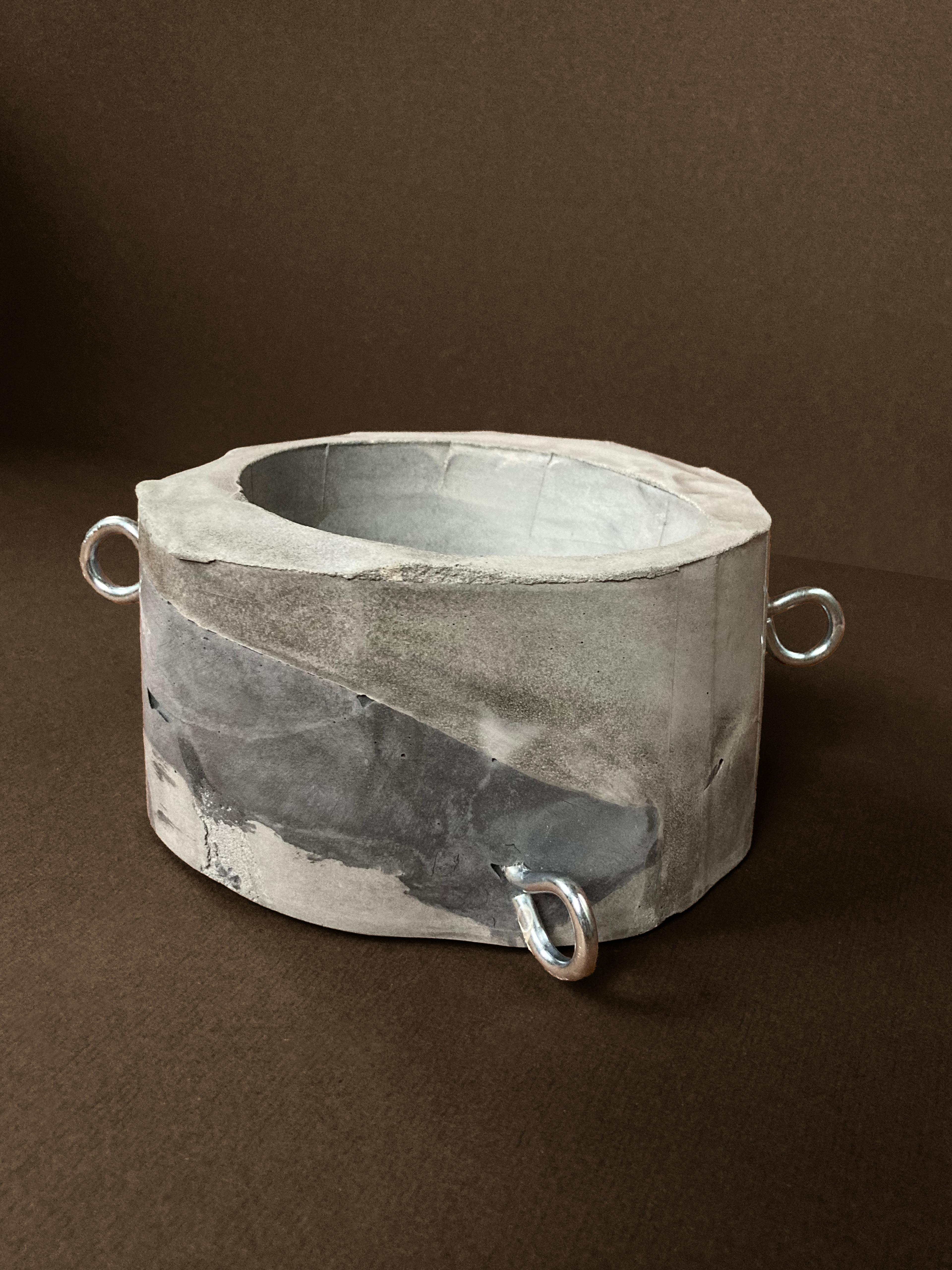 Run Your Finger Over My Hoops — a faceted concrete planter with three chrome rods, unplanted, view 3 of 3