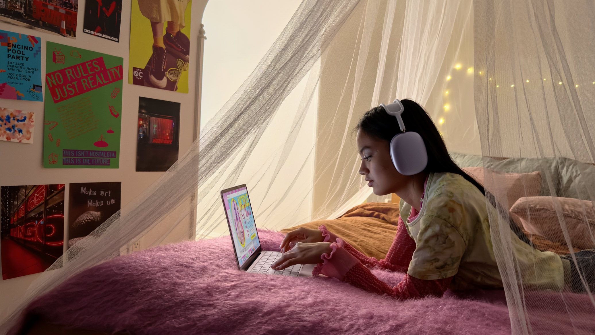 Une jeune personne dans sa chambre, portant un casque d’écoute, utilise un MacBook Neo rose poudré pour prendre rendez-vous pour une manucure