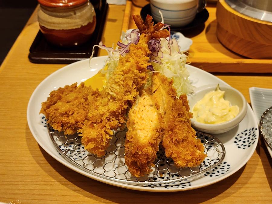 The Nanban Saikachi ladies set at Tonkatsu Wako: a breaded prawn, a fried salmon fillet cut to show the orange flesh and a bite-size pork fillet cutlet on a wire rack with cabbage and a dish of tartare sauce.
