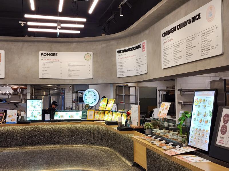 Curved concrete counters at LOFTER for congee, Vietnamese food and crabmeat curry, with display plates on the counter.