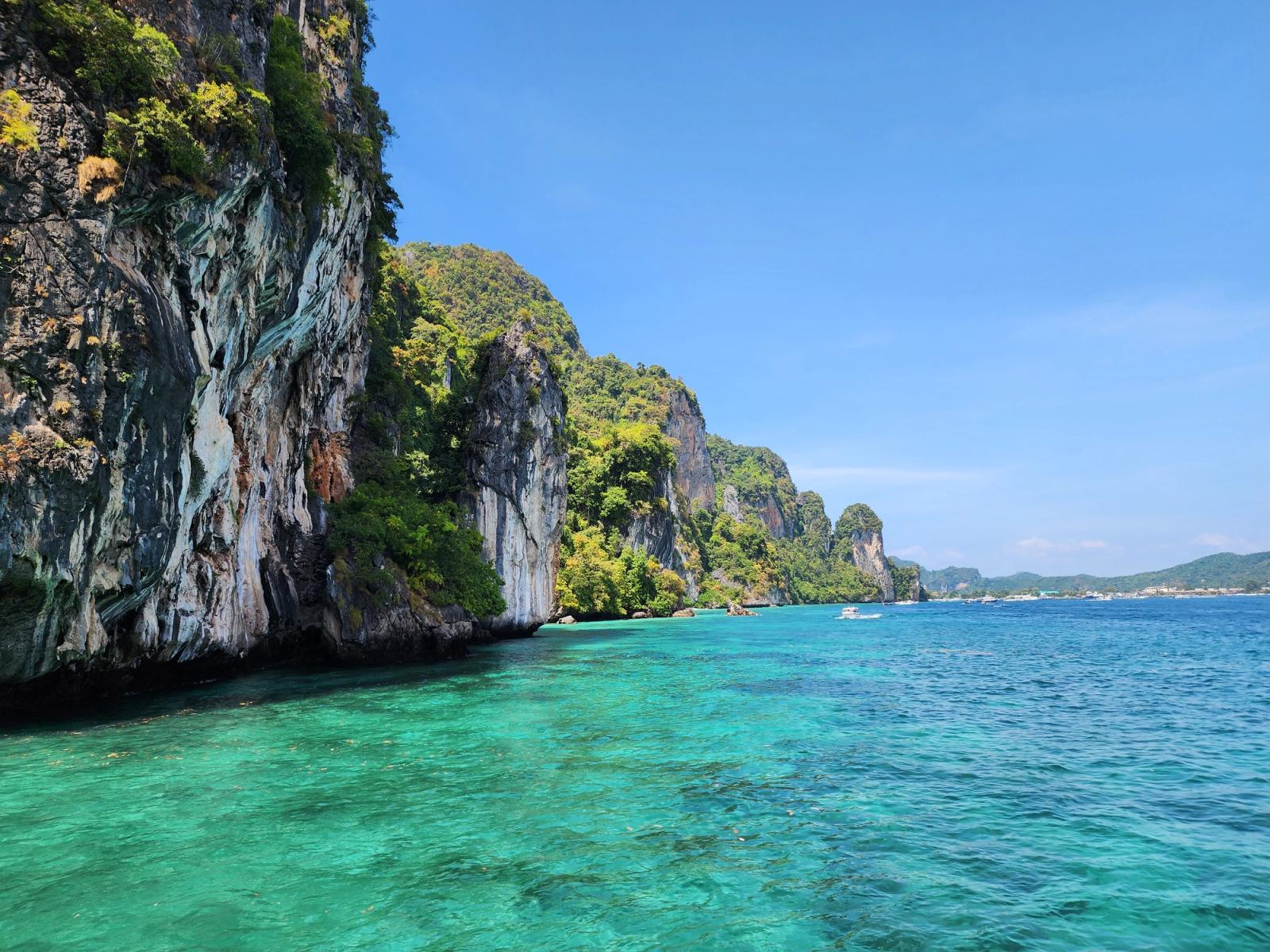 Limestone karst cliffs rising from turquoise water near Phi Phi, southern Thailand.