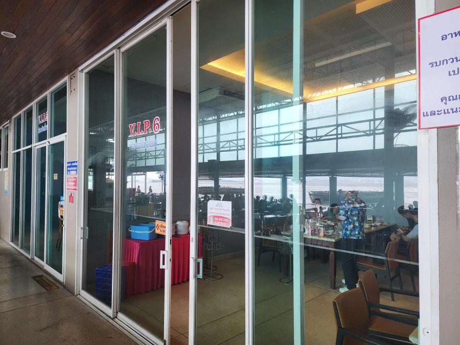 Glass-fronted VIP dining rooms at Moom Aroi with red V.I.P. 6 lettering on the window and a booking sign on the door.
