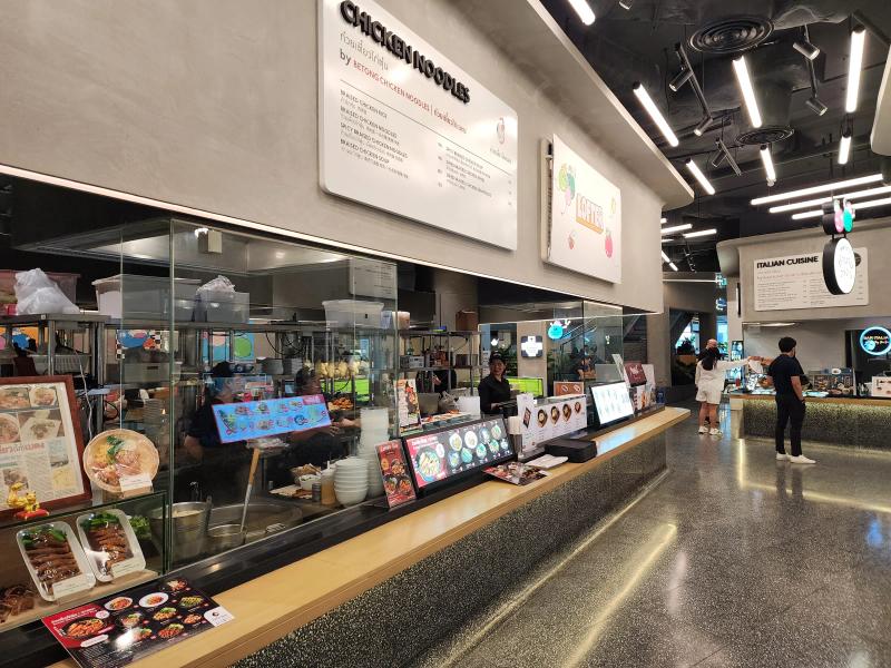 A chicken noodle counter at LOFTER with display dishes behind glass and the kitchen visible beyond.
