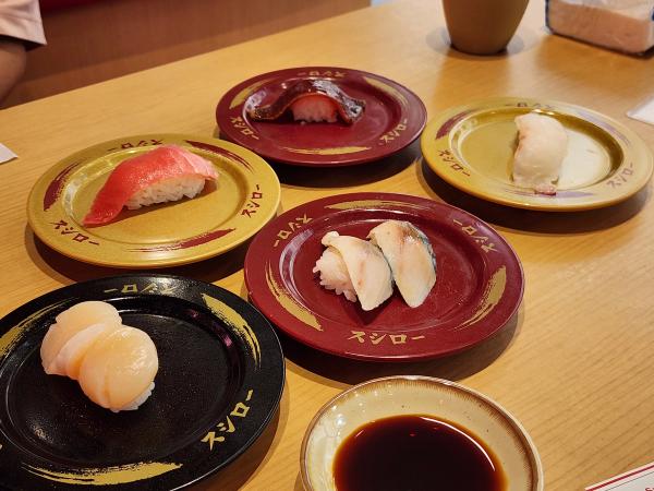Nigiri on colour-coded plates at Sushiro PARC Bangna, with soy sauce in a small dish.