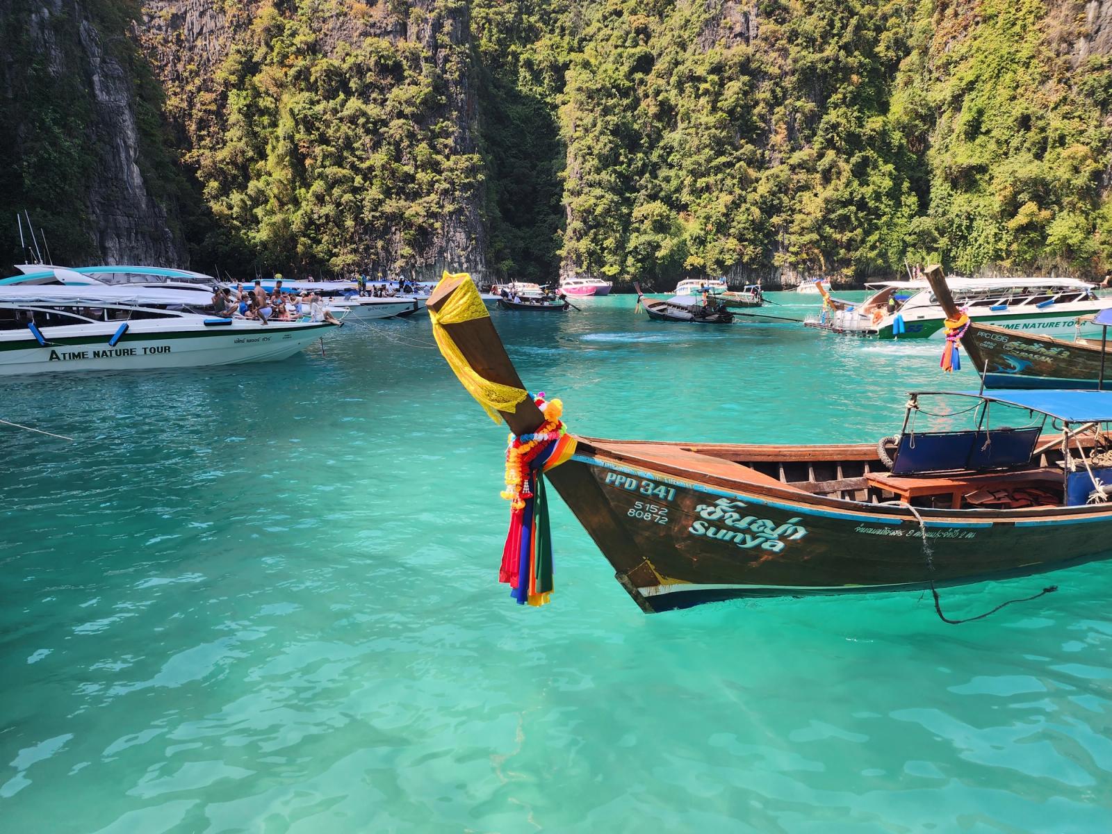 A longtail boat in clear blue water.