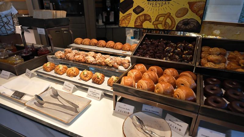 Trays of croissants, doughnuts and pastries on the bakery counter at Bella Sera under a Fresh Baked Everyday sign.