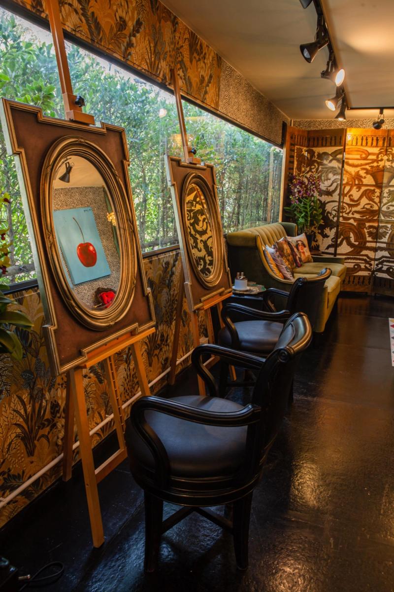 Styling chairs and gilt-framed mirrors on easels lining the window wall inside Libertish Salon Cafe.