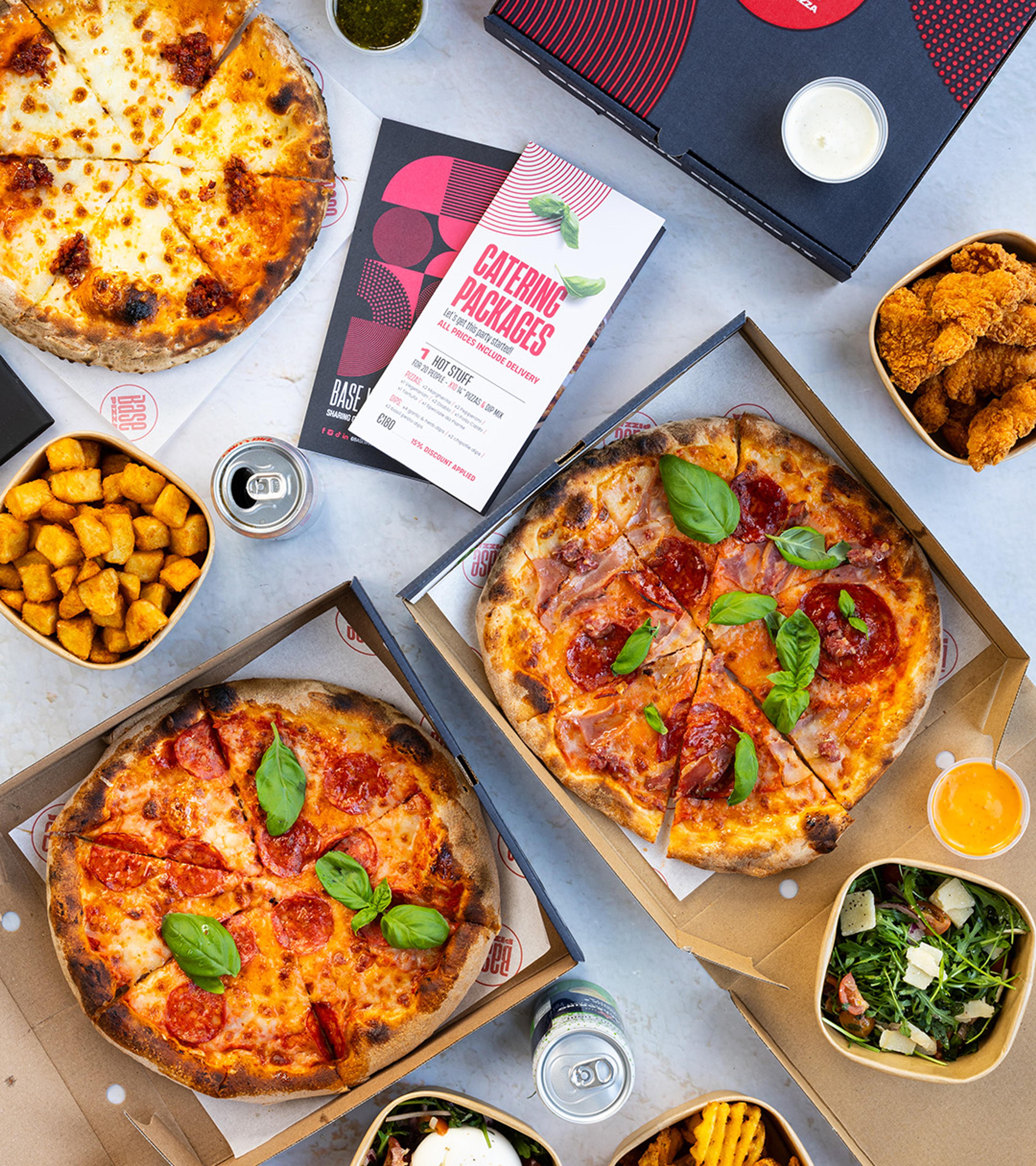 Base pizzas, sides and dips laid out for an office lunch