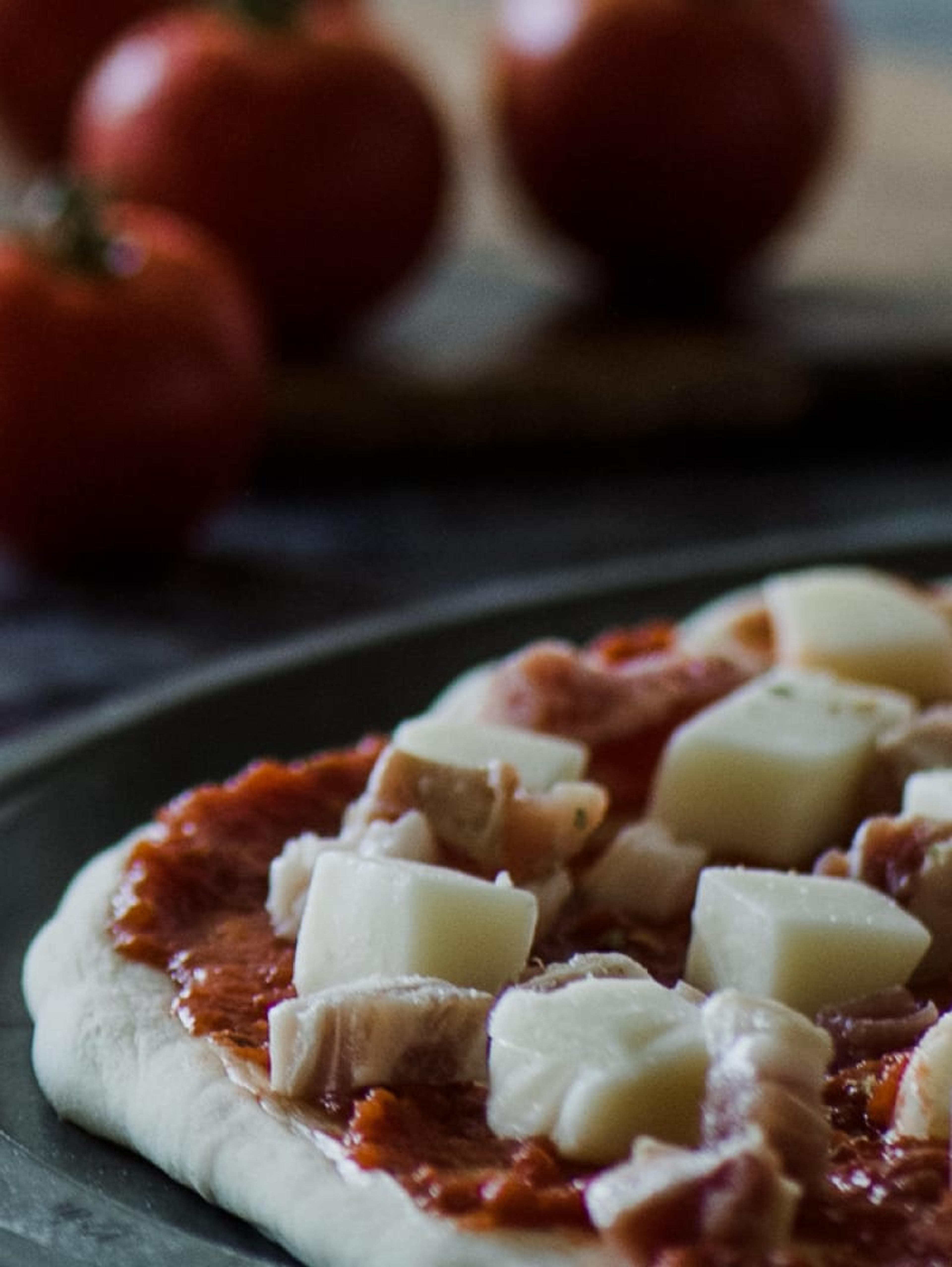 Fresh mozzarella pieces on a pizza base