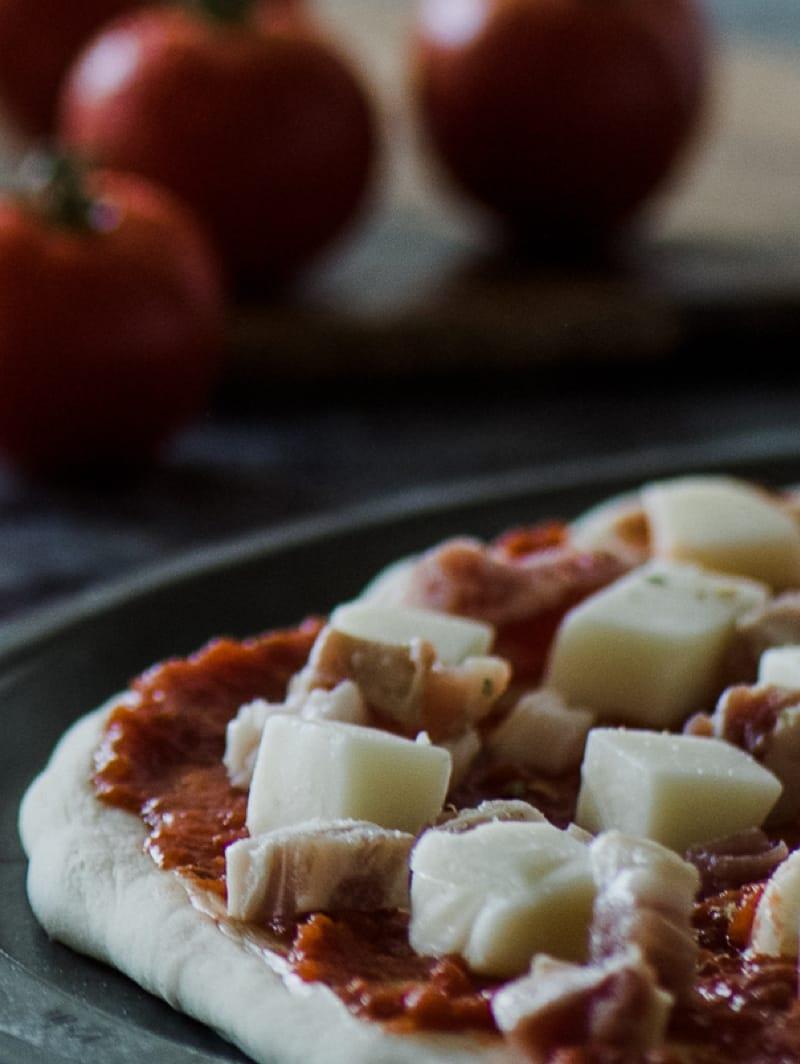 Fresh mozzarella pieces on a pizza base