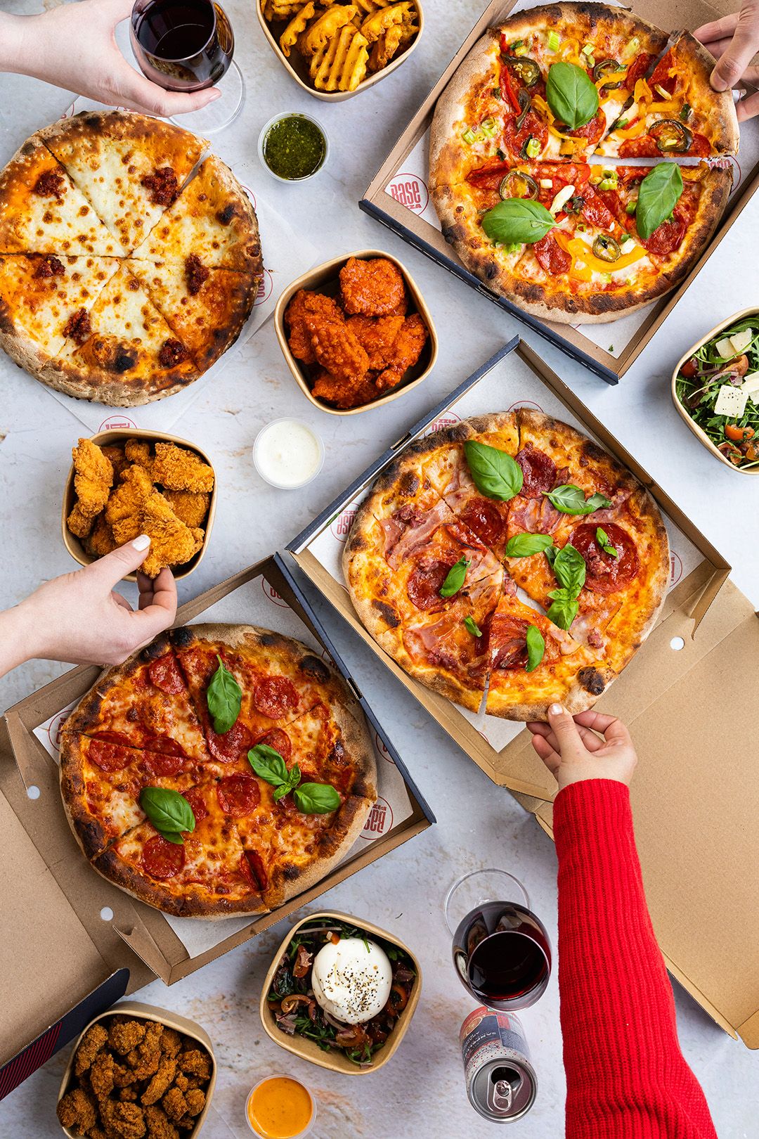 Table spread with Base pizzas, sides and drinks