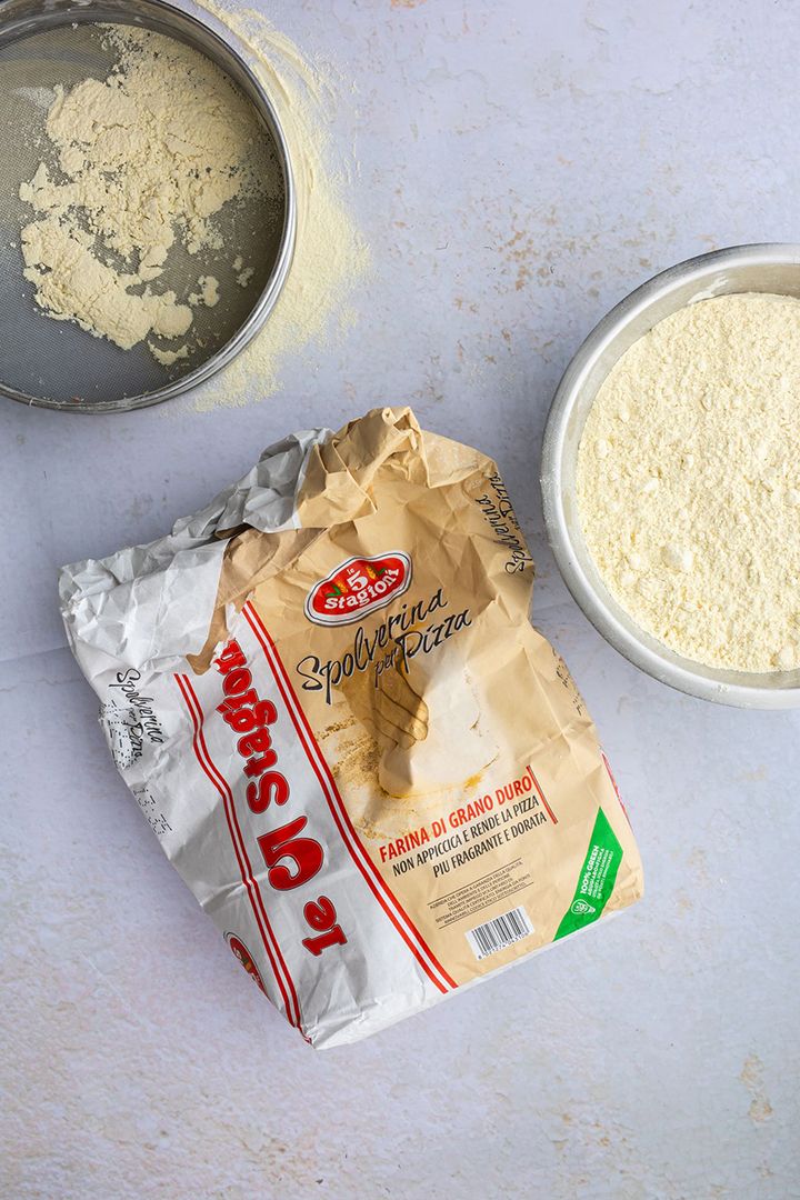 Bag of Italian flour beside bowls of flour