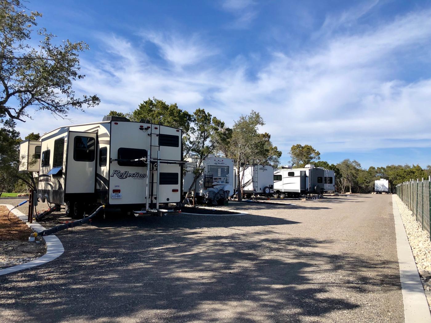 Full-hookup RV sites at Wayside Wimberley with paved pads and Hill Country trees
