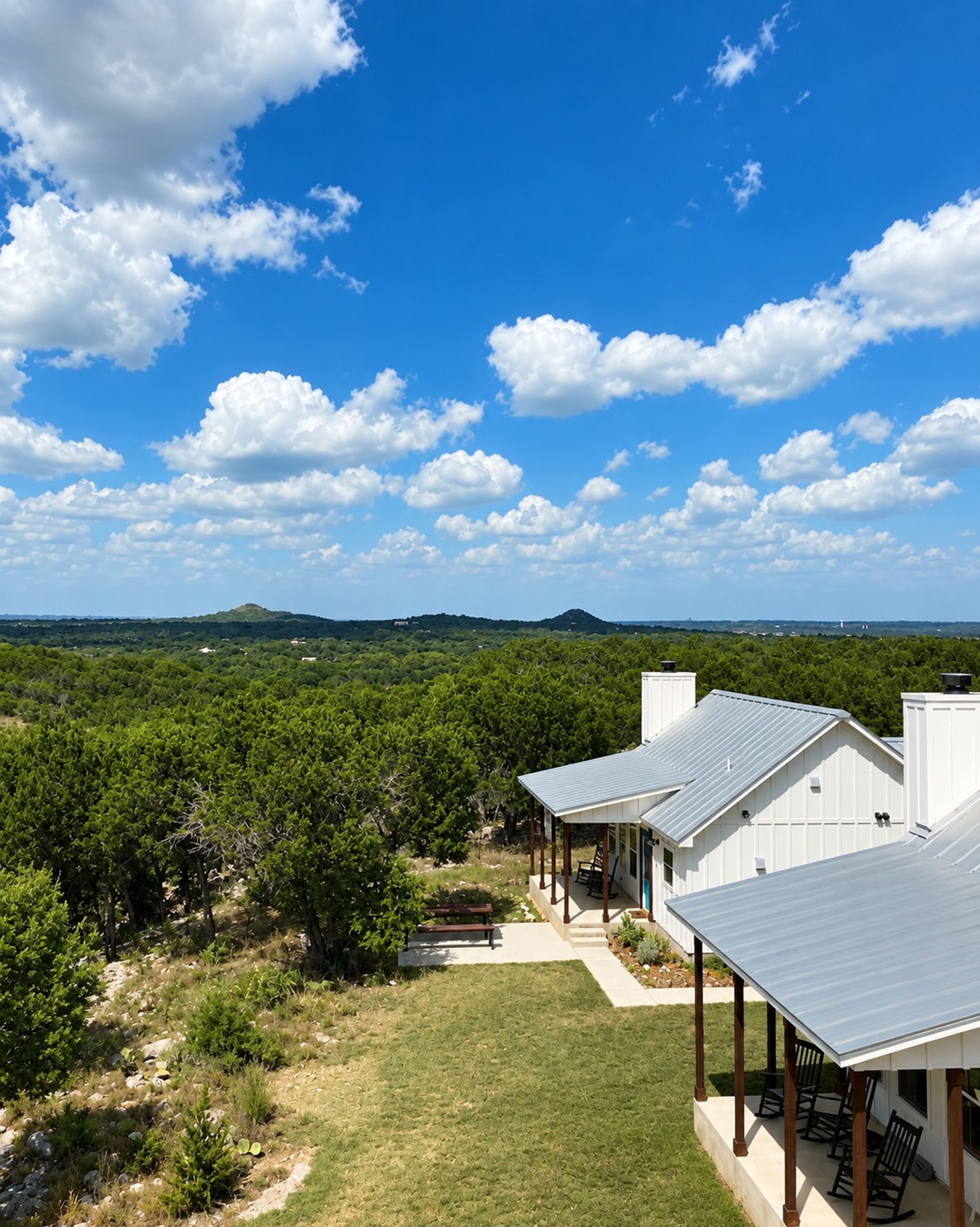 An aerial view of the farmhouse cottages at Wayside Wimberley with the Hill Country stretching to the horizon