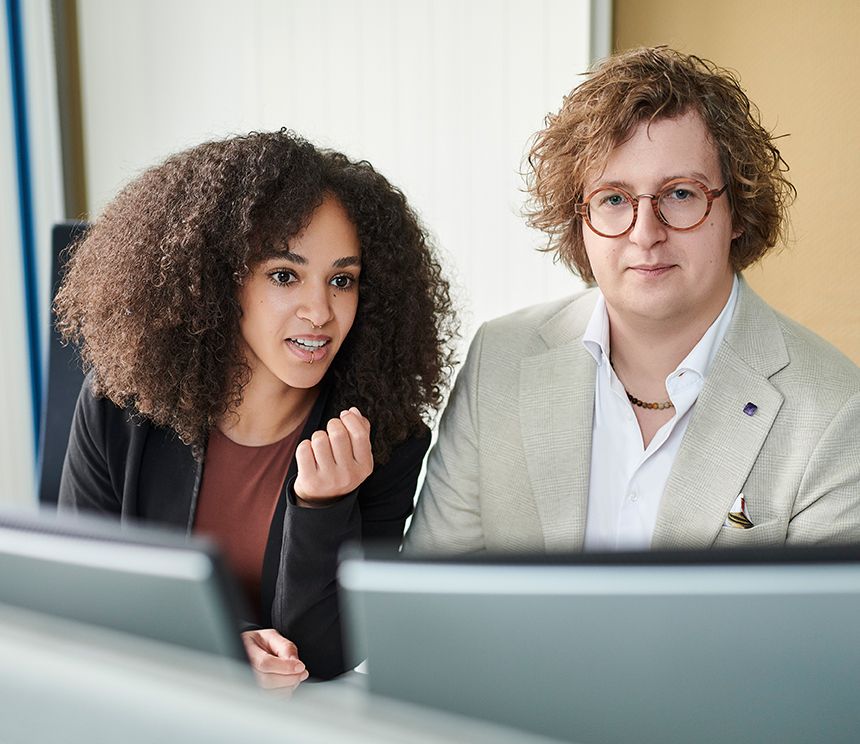 Dual Studierende arbeiten gemeinsam mit erfahrenen Mitarbeitenden an Aufgaben aus der Softwareentwicklung