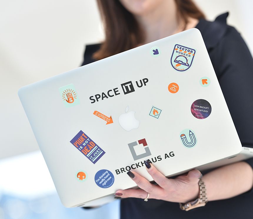 Laptop mit SpaceITup-Aufklebern als Symbol für hybrides Arbeiten während eines Dualen Studiums in der IT