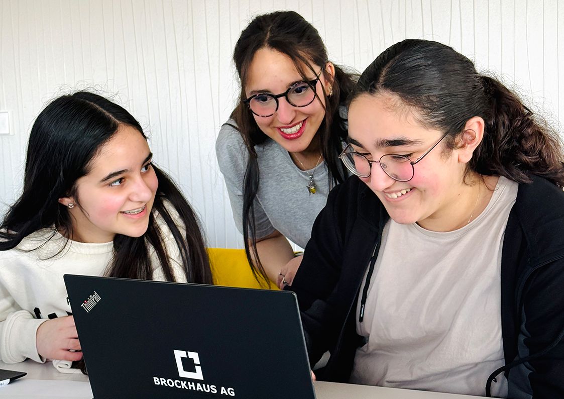 IT-Girls in der Softwareentwicklung bei der BROCKHAUS AG Drei Teilnehmerinnen arbeiten gemeinsam an einem Laptop im Rahmen eines IT- und Softwareentwicklungsprojekts bei der BROCKHAUS AG