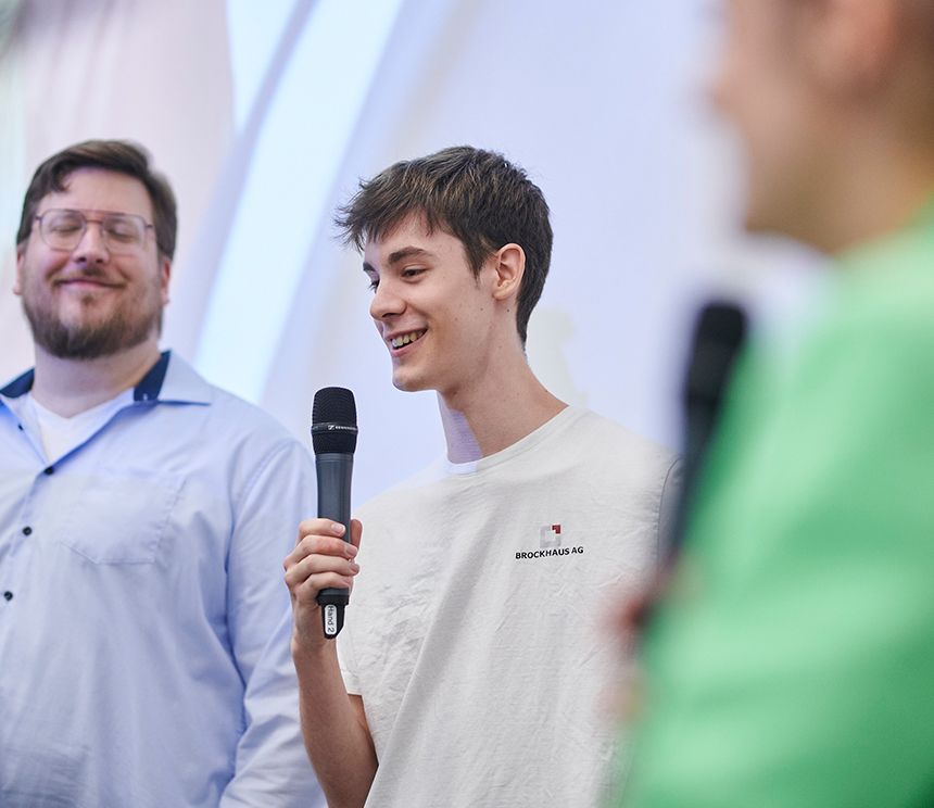 Werkstudent präsentiert Inhalte vor einem Publikum als Beispiel für Entwicklungsmöglichkeiten und Verantwortung im Unternehmen