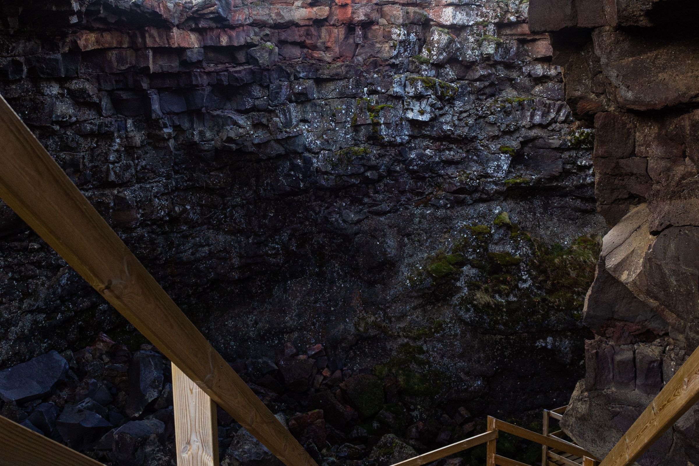 wooden stairs at the entry of a lava cave