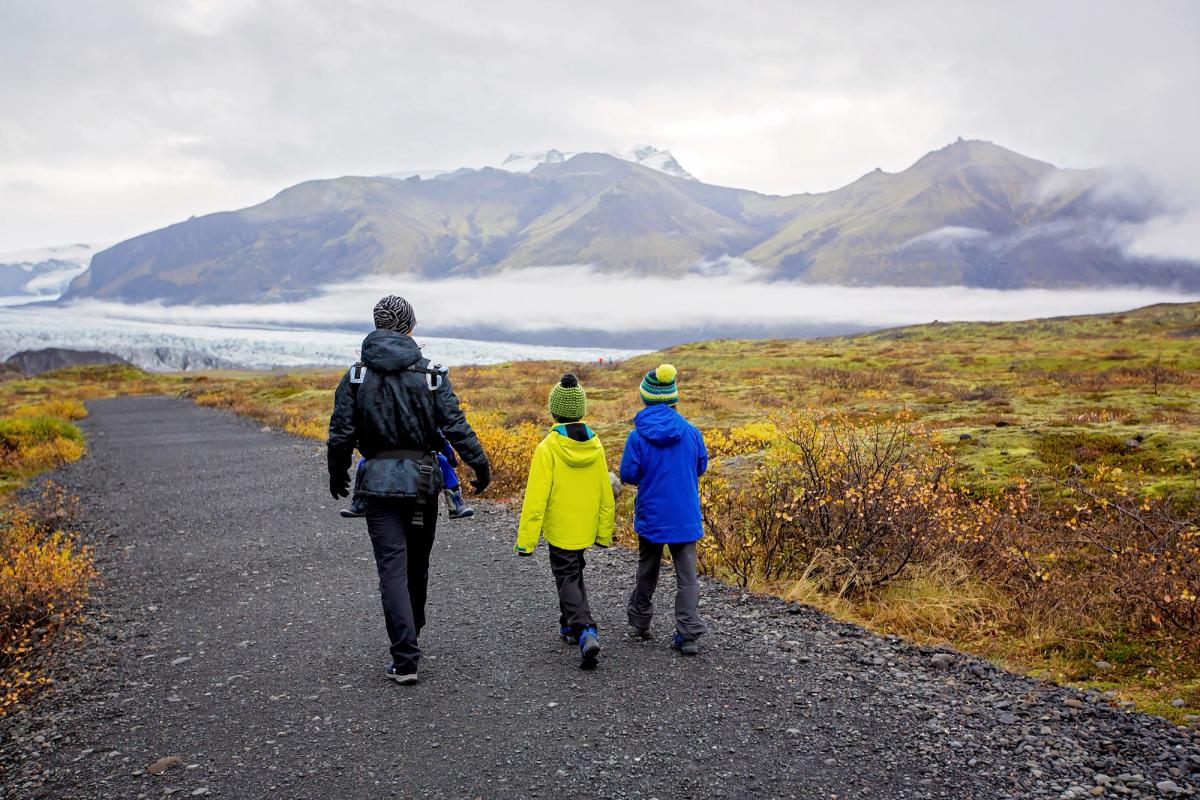 Familia caminando por un sendero en Islandia en otoño
