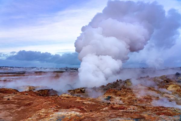a large cloud of steam is coming out of a volcano .