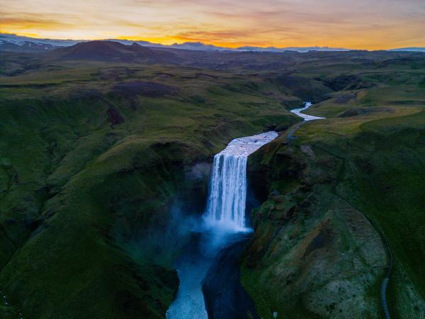 aerial view of a river and its waterfall at sunset