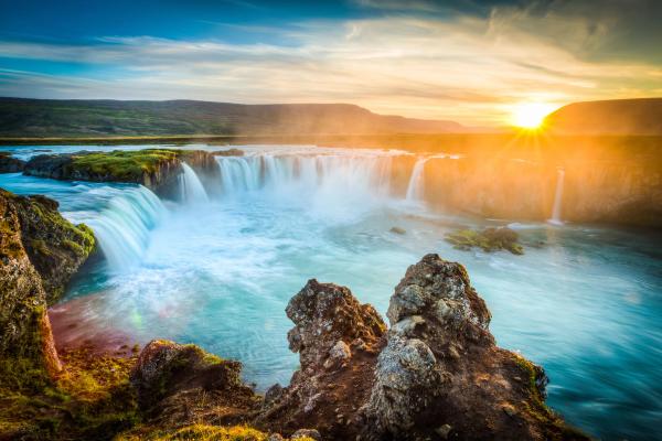 Panoramic view on the Godafoss waterfall and its green landscapes ,accompanied by a beautiful sunset