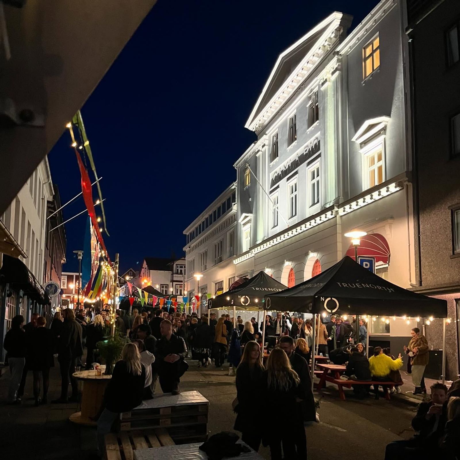 a crowd of people are gathered outside of a building at night .