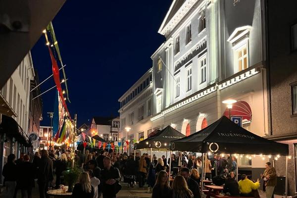 a crowd of people are gathered outside of a building at night .