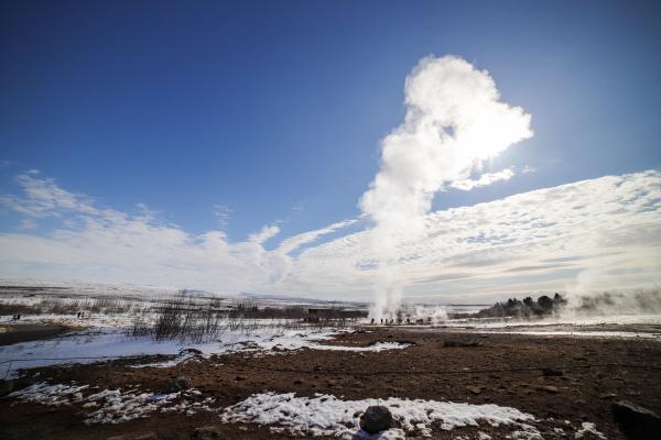 un géiser está entrando en erupción en medio de un campo nevado.