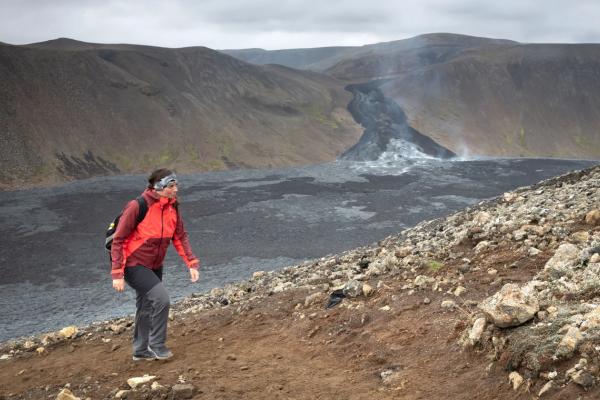 Hiker in iceland A view of a hiking path in Iceland with volcanic activity in the background