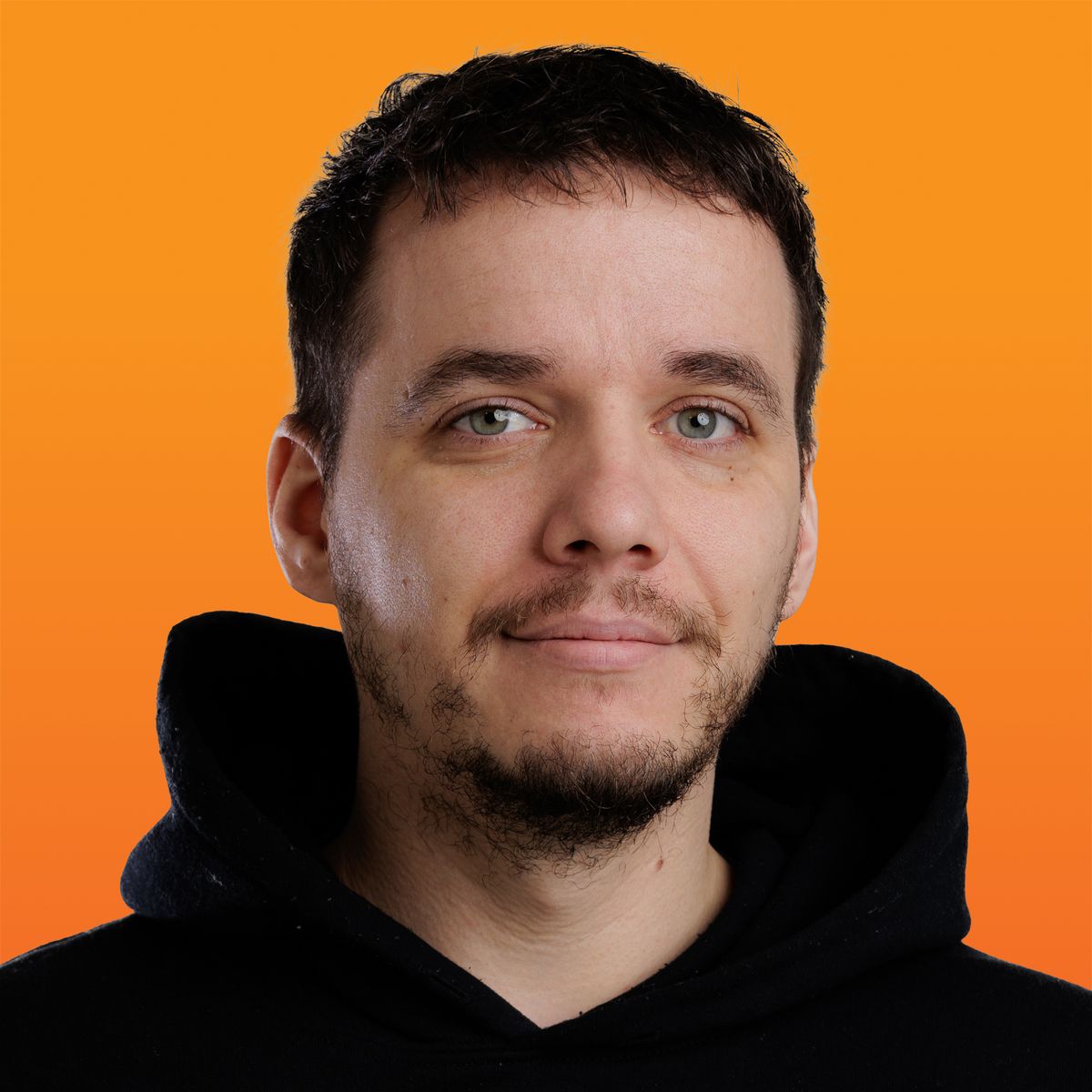 Headshot of a man with dark hair and a beard, wearing a black hoodie, smiling slightly against an orange background.