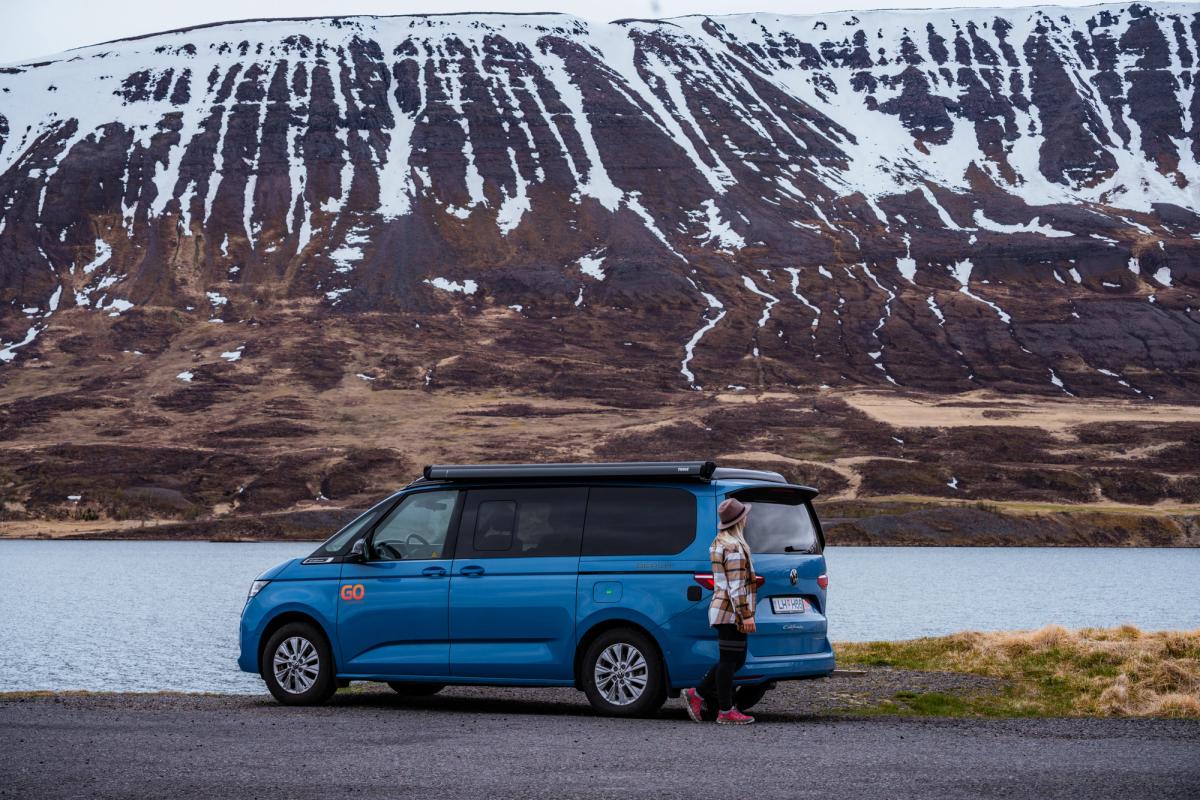 Side view of a 4x4 campervan that sleeps 2 beside open water, camper van rental Iceland